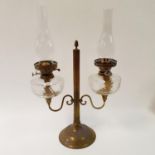 A brass double oil lamp, with clear glass wells, 65 cm high