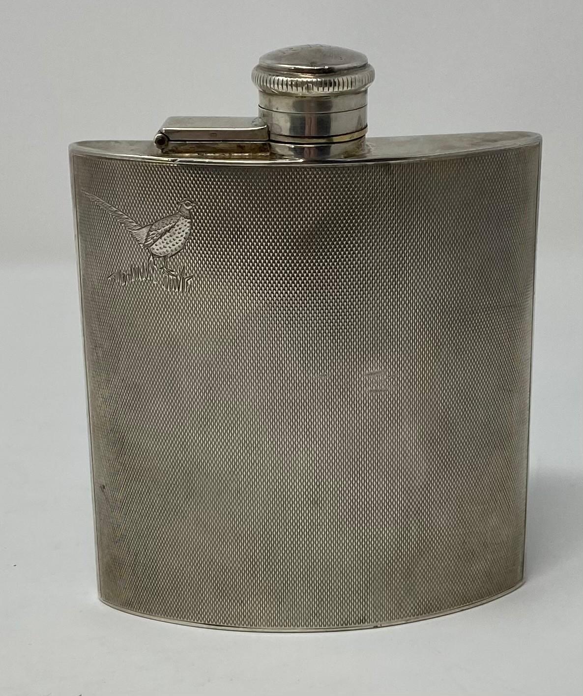 A silver hip flask, engraved a cock pheasant, and with engine turned decoration, initialed,