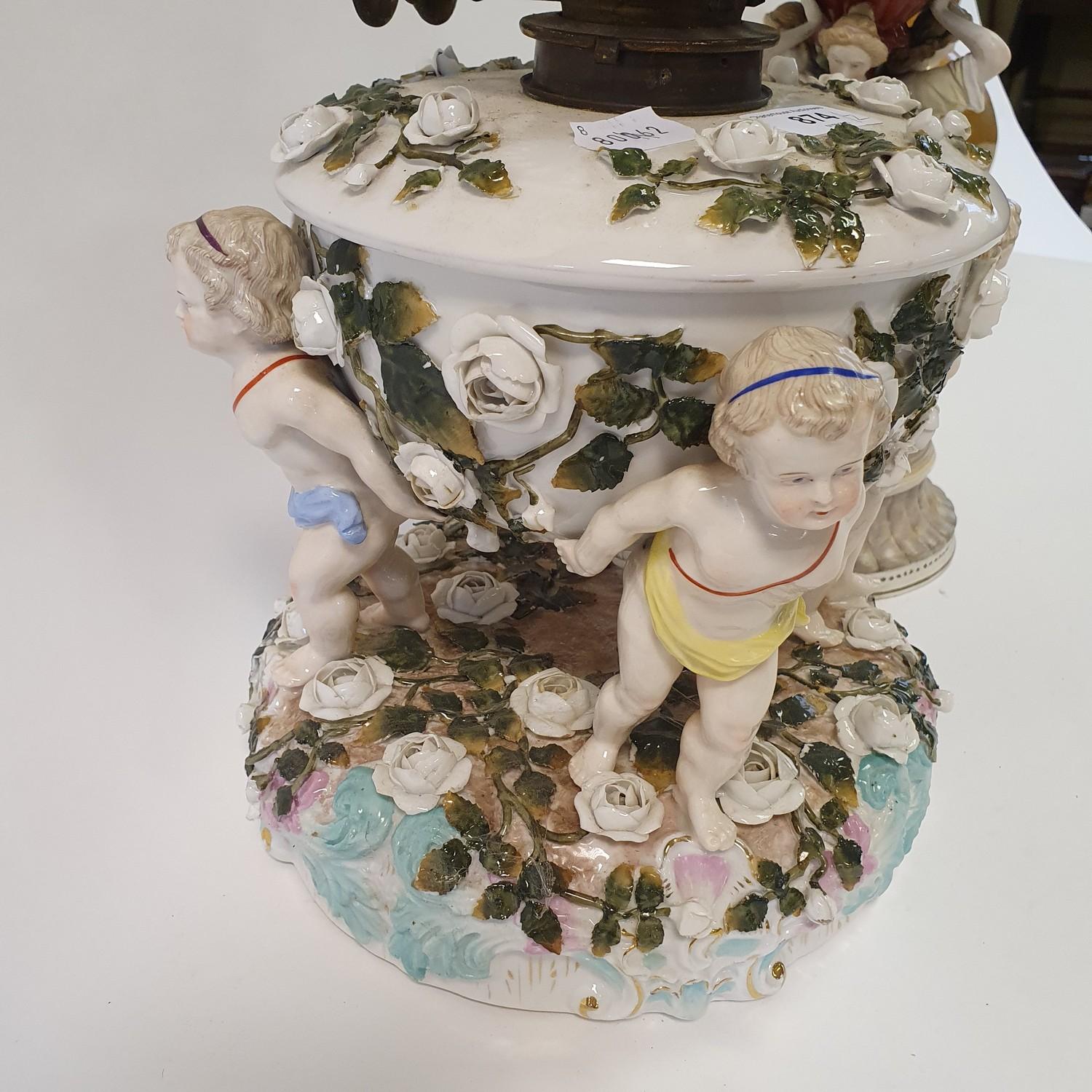 A Dresden porcelain oil lamp, flower encrusted well raised by three putti, 55 cm high, and an oil - Image 4 of 11