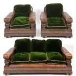 A 1920s leather and carved oak country house three piece suite, with green velvet cushions, padded