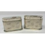 A pair of plated table top cigarette lighters, decorated shells, 9 cm wide 6 cm high