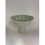 A Chinese celadon ground porcelain stem bowl, incised with lotus flowers, and with characters to the