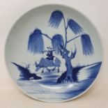 A Chinese shallow dish, decorated a man playing a flute riding on a water buffalo, cracked, 28 cm