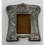An early 20th century silver mounted strut photograph frame, embossed a lady picking apples,