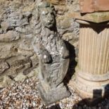 A composite stone garden statue in the form of a lion holding a shield, 88 cm high