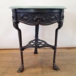 An Art Nouveau cast iron pub table, raised on three legs united by under tier, with a later