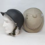 A German WWII helmet, a safari pith helmet, and a porcelain head hat stand (3)