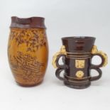 A Dicker three handled jug, 18 cm high, a slip glazed jug, decorated mushrooms, 25 cm high, three