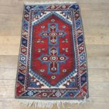 A Persian red ground rug, 118 x 79 cm, a runner, 300 x 84 cm, a blue ground rug, 177 x 125 cm, and a