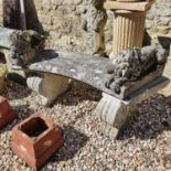 A composite stone garden bench, 96 cm wide, and a pair of composite stone garden ornaments, in the