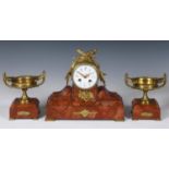 An early 20th century clock garniture, the clock with an 11 cm diameter dial, in a gilt metal and