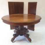 An oak extending dining table, on a carved column, 41 cm diameter, with three extra leaves