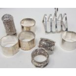 A silver toast rack, six silver napkin rings and an Indian silver coloured metal pepper pot, 9.5 ozt