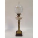 An oil lamp, with an acid etched glass shade, a clear glass well, on a brass base in the form of a