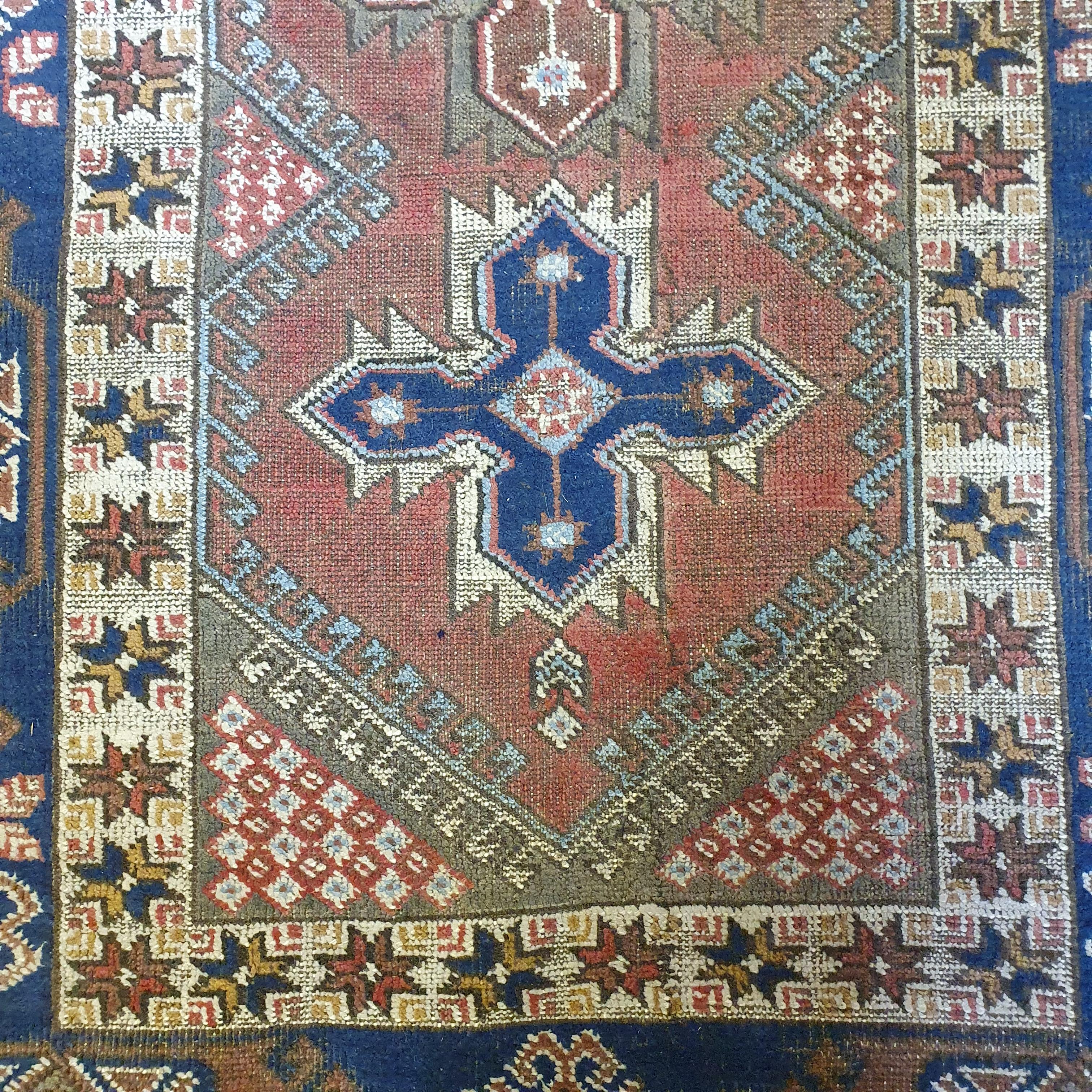 A Persian red ground rug, main blue boarder, the centre with three geometric medallions, 187 x 124 - Image 2 of 5