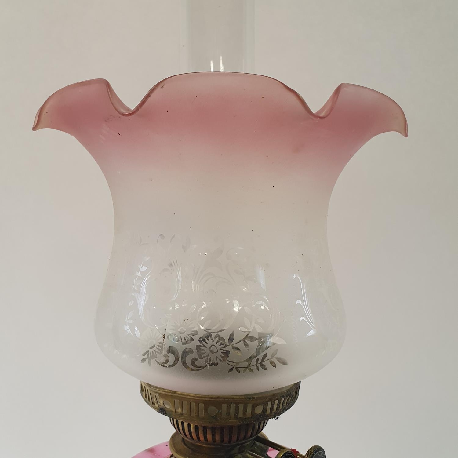 An oil lamp, with a cranberry tinted acid etched glass shade, a cranberry glass well, on a brass - Image 3 of 3