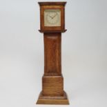 A timepiece, the 4.5 cm square dial in an oak case, in the form of a longcase clock, 29.5 cm high