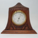 An early 20th century barometer and thermometer, in an oak case carved two guns and two