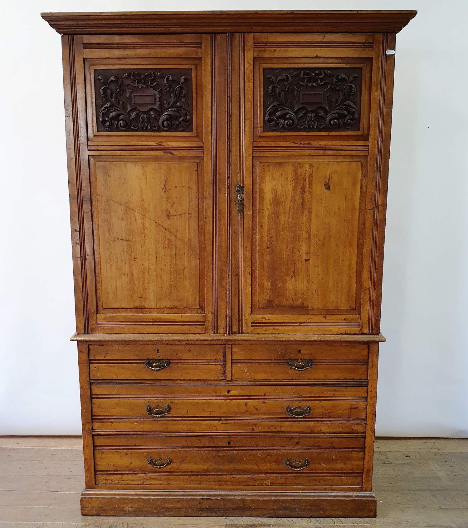 An early 20th century walnut linen press, with two doors, to reveal slides, on a base with two