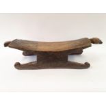 An African carved wood stool, 90 cm wide