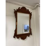 A mahogany fret framed wall mirror, 81 x 50 cm, another and an oval mirror (3) Oval mirror from a