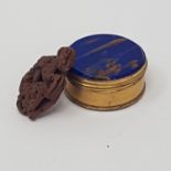 An early 20th century pill box, lid inset with blue stone with metallic flecking, base a mother or