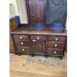 A pine sideboard, having seven drawers and a single cupboard door, 154 cm wide