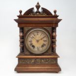 A mantel clock, the 11 cm diameter silvered dial with Roman numerals, in walnut case 33 cm high