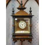 A wall clock, the 10 cm diameter dial with Roman numerals, in a walnut and ebonised case, 65 cm high