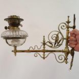 A late 19th/early 20th century wall mounted oil lamp, with a clear glass well, 41 cm wide Various