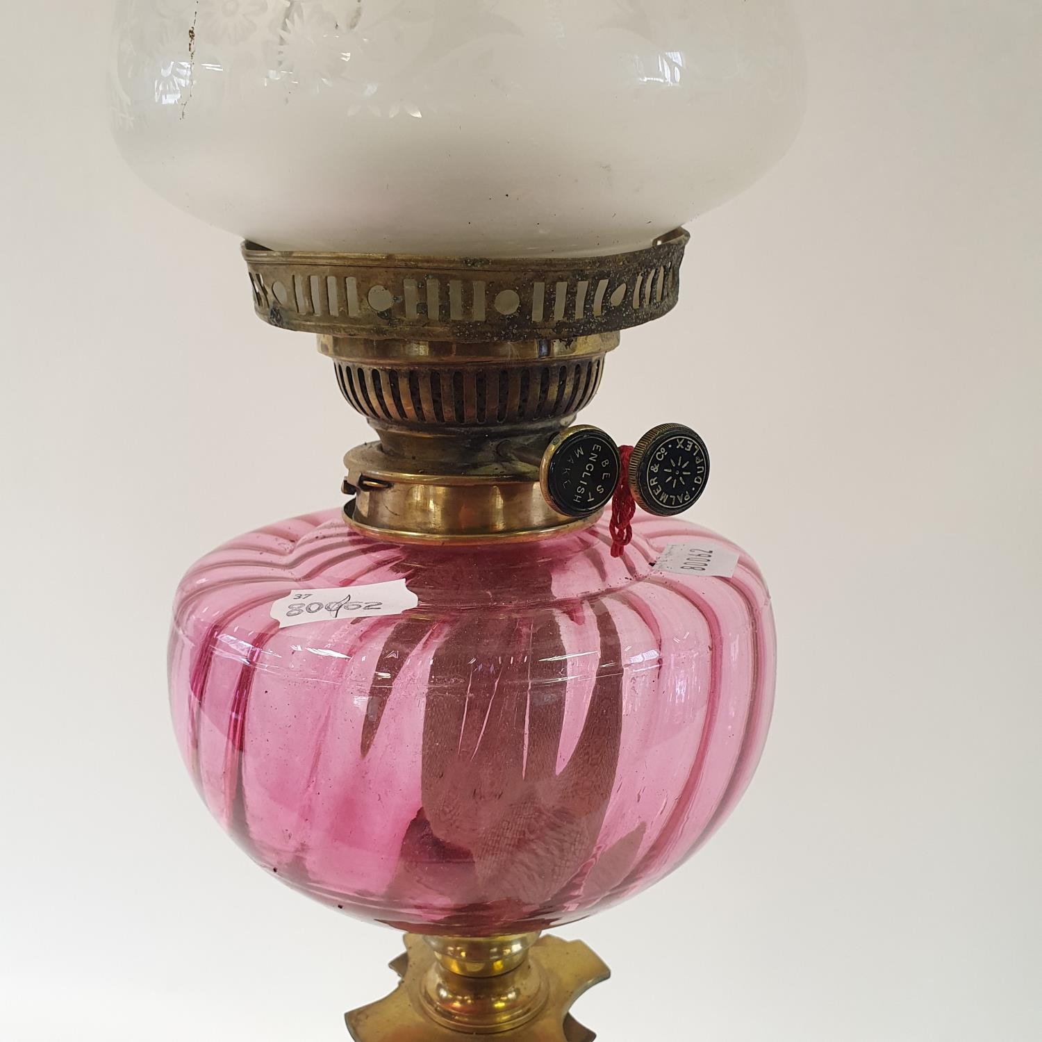 An oil lamp, with a cranberry tinted acid etched glass shade, a cranberry glass well, on a brass - Image 2 of 3