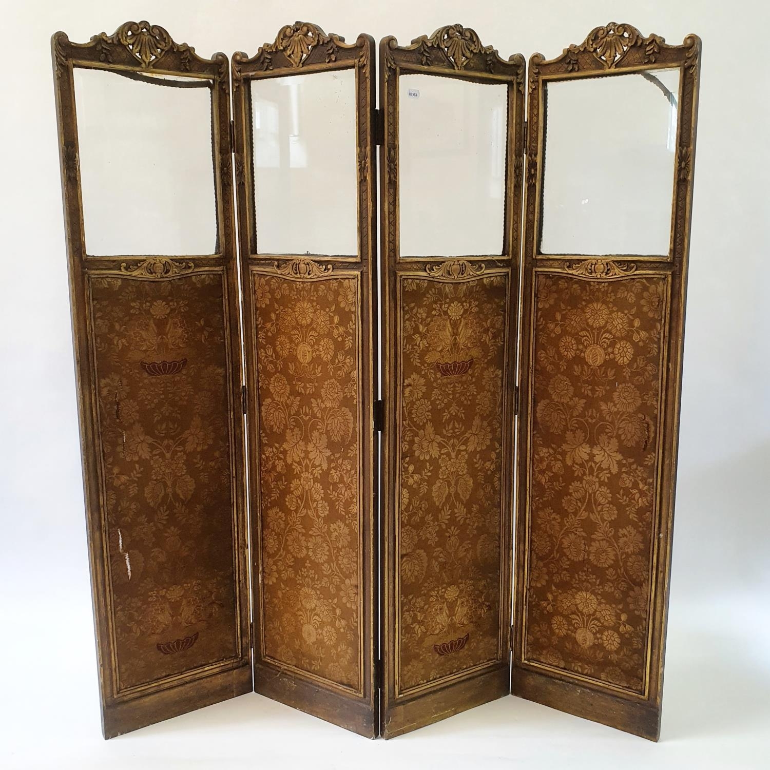 An early 20th century painted four panel screen, the top with glazed sections above silk panels