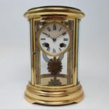 A mantel clock, the 7.5 cm diameter enamel dial with Roman numerals, fitted an eight day movement,