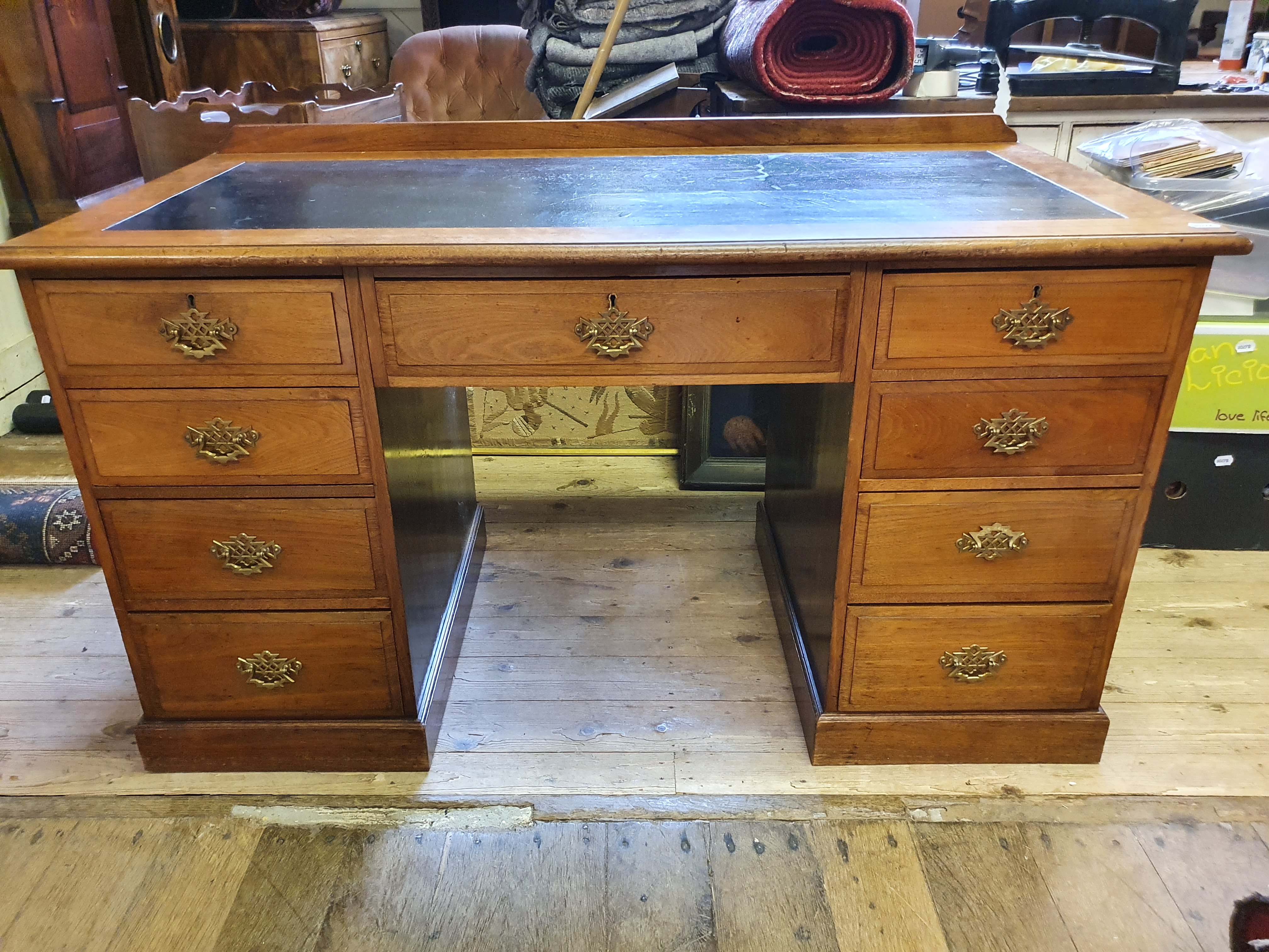 An early 20th century mahogany knee hole desk, having nine drawers, 140 cm wide