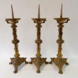 A set of three brass ecclesiastical style pricket candlesticks, 63 cm high (3)