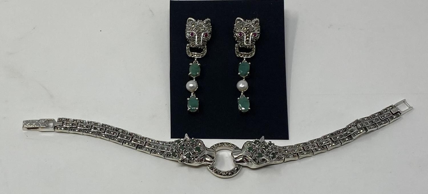 A silver, emerald and marcasite set head bracelet and earrings This is a modern copy