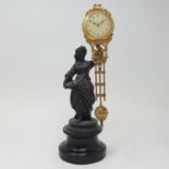 An early 20th century mystery clock, mounted on a spelter figure, on a wooden base, 30 cm high (