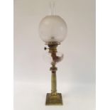 An oil lamp, with an acid etched glass shade, a clear glass well on brass and onyx base, 72 cm