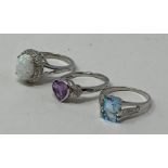 A silver, opal and diamond ring, a silver topaz ring, and a silver and amethyst ring (3) This is a