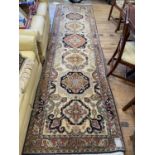 A Persian cream ground runner, multiple borders centre with repeating medallions, 349 x 100 cm