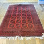 An Afghan red ground carpet, 272 x 188 cm