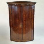 A 19th century oak bow front corner cabinet, 69 cm wide
