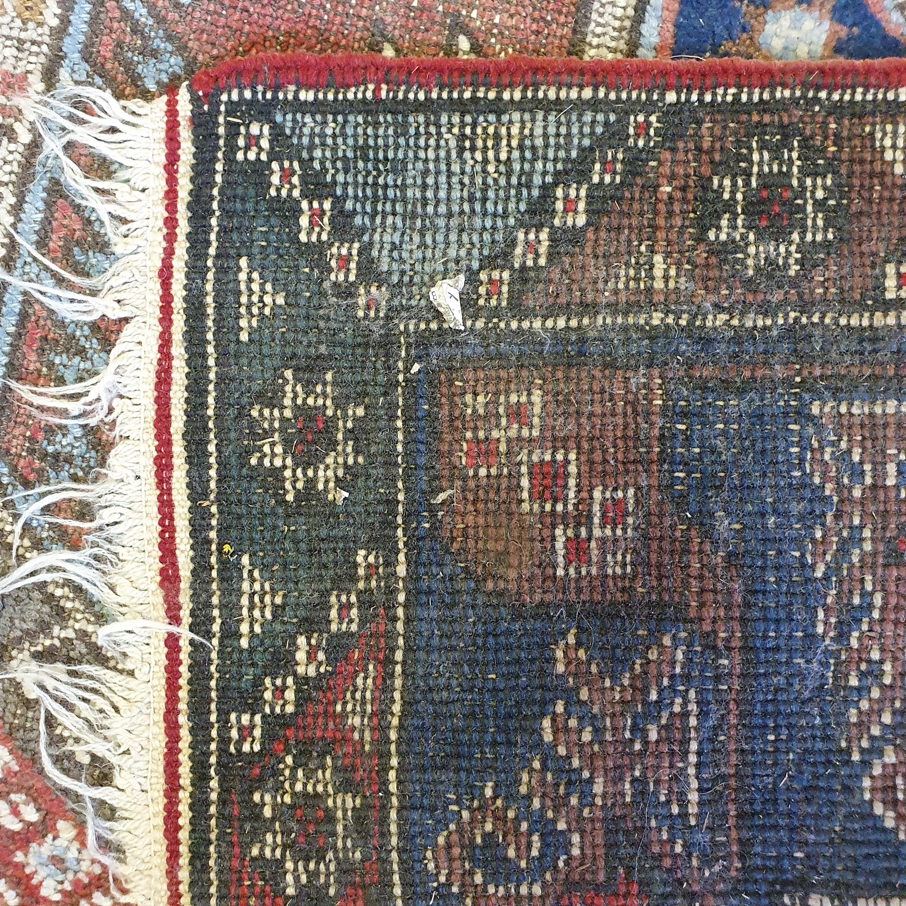 A Persian red ground rug, main blue boarder, the centre with three geometric medallions, 187 x 124 - Image 3 of 5