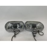 A pair of Lucas Quartz-Halogen driving lamps, with covers, a Cibie driving lamp, with a cover, and a