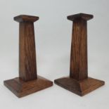 A pair of Arts and Crafts oak candlesticks, 19 cm high