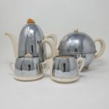 An Art Deco three piece tea set, with silver plated covers, and a similar teapot (4) The ceramic