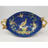 A Spode oval twin handled bowl, the blue ground decorated birds, highlighted with gilt, 36 cm high