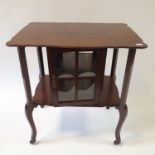 A Liberty's style mahogany side table, with shaped top above a glazed cupboard door, on scroll
