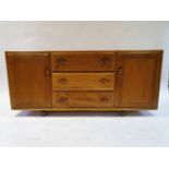 An Ercol light elm sideboard, with three central drawers and two cupboard doors, 155 cm wide