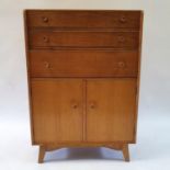 A 1970s oak compactum, having three drawers above two cupboard doors, 76 cm wide